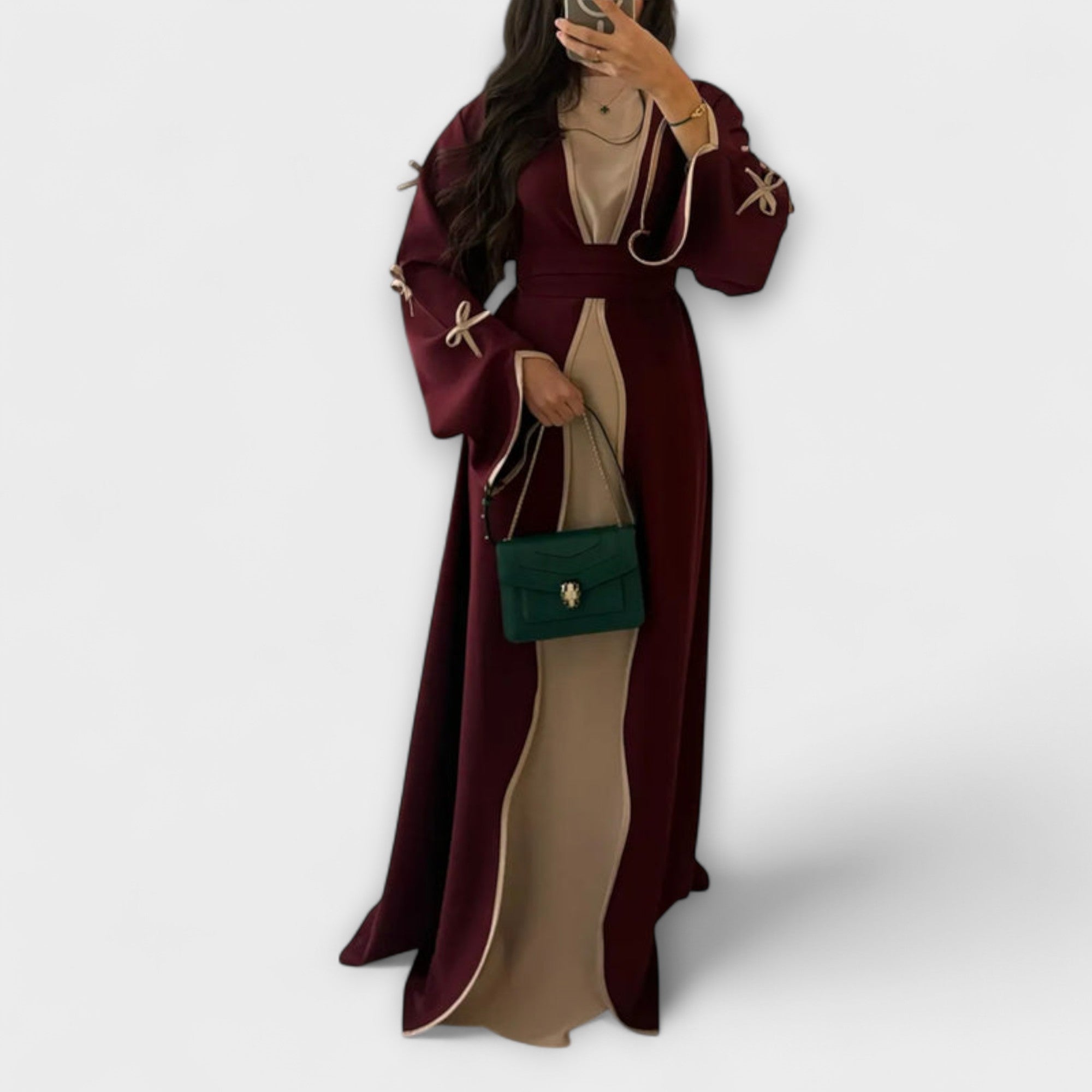 Elegantni kardigan in obleka v kombinaciji s prugastim vzorcem.