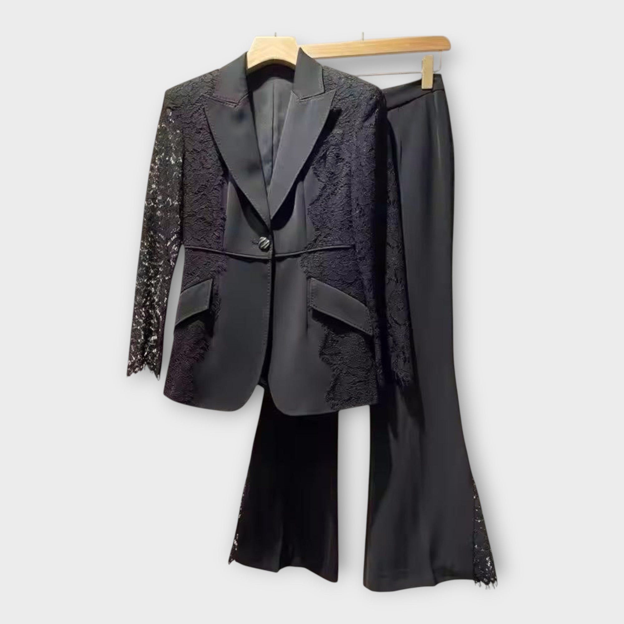 Elegantna obleka, sestavljena iz jakne in hlač, z detajli iz čipke.
