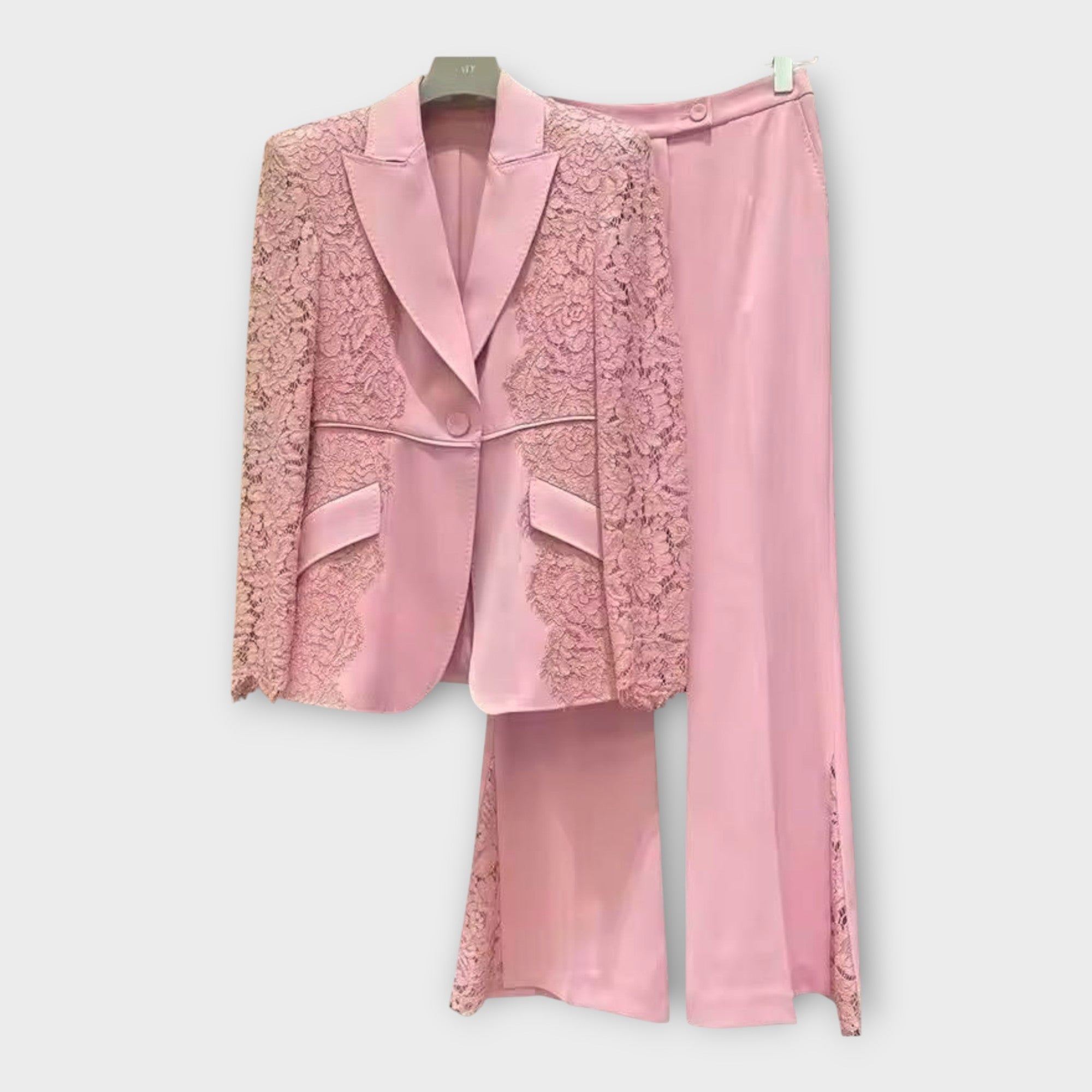 Elegantna obleka, sestavljena iz jakne in hlač, z detajli iz čipke.